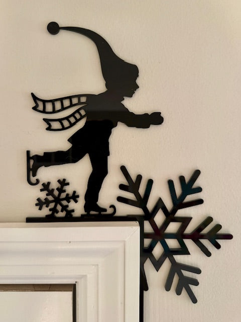 Decorative acrylic door art of a skater with snowflakes.