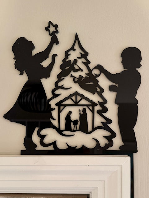 Decorative door art with silhouettes of children and a nativity scene.