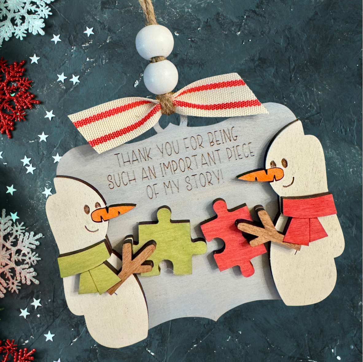 Decorative ornament with snowmen and puzzle pieces.